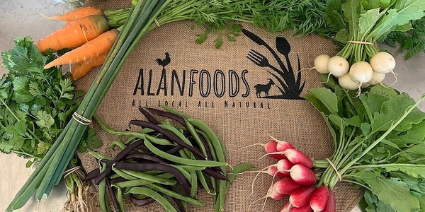 Various vegetables on top of a hessian cloth with the Alan Foods branding