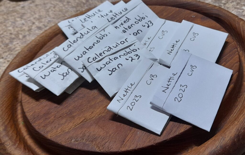 Origami seed packets, labelled with the date stored and the suburb they were grown
